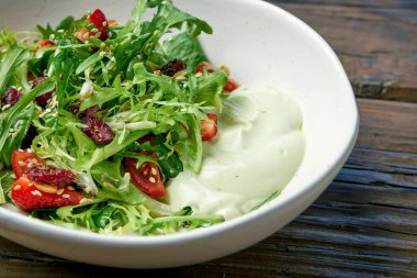 Kiraz domatesli vejetaryen salatası, avokado mus ve ahşap arka planda bir kasede çilek.