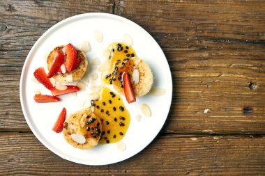 Tahta arka planda badem, çilek ve çarkıfelek reçelli vejetaryen tofu peynirli kekler.
