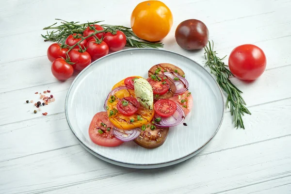 木製の背景に灰色のプレートに3種類のトマト 玉ねぎ ソースのおいしいベジタリアンサラダ — ストック写真