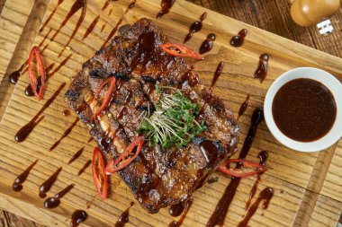 Kavrulmuş ızgara domuz pirzolası, tatlı ve ekşi soslu ahşap arka planda salata. Bira için lezzetli yemekler.