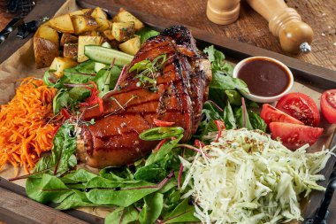 Birada kızarmış domuz budu ve ballı domates, lahana ve patates. Geleneksel Alman birası.