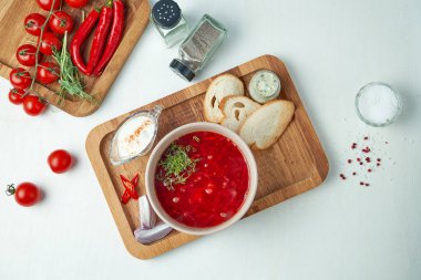 Beyaz arka planda ahşap bir tepside ekşi krema, soğan ve domuz yağı ile klasik Ukrayna borsch kompozisyonu. Üst Manzara. Düz yerde yemek vardı.