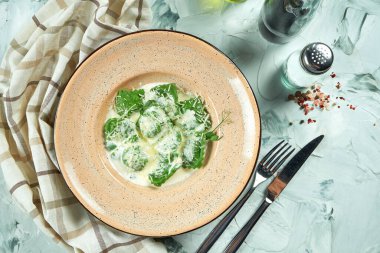 İtalyan geleneksel yeşil ravioli, seramik tabakta kremalı soslu ıspanak.