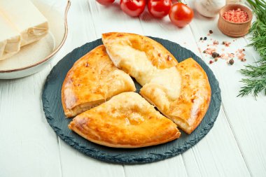Lezzetli geleneksel Khachapuri 'ye yakından bakın - eritilmiş tuzlu peynirle doldurulmuş kapalı turta (suluguni). Gürcü yemekleri