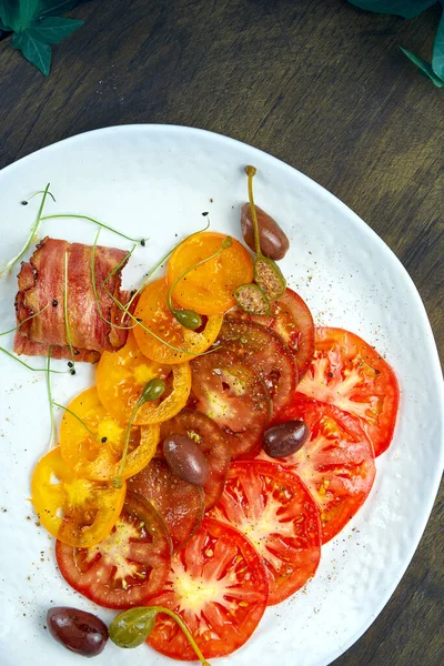 木製の背景に白いプレートにケッパーとベーコンとトマトカルパッチョ イタリア前菜 — ストック写真
