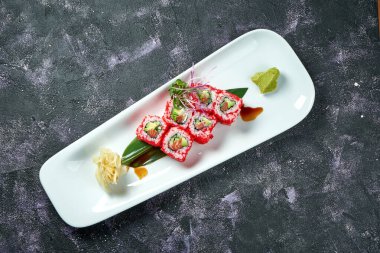 Japon suşisi avokado, somon balığı ve beyaz tabakta tobiko havyarı ile yuvarlanır. Kaliforniya 'yı döndürün. Üst görünüm