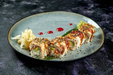 Japon suşisi, yılan balığı, somon, avokado ve krem peynirli mavi tabakta. Kapat.