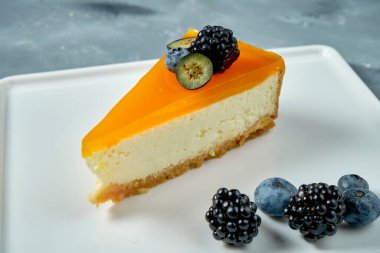 İştah açıcı tatlı. Karamelli cheesecake ve beyaz tabakta böğürtlen. Lezzetli hamur işi