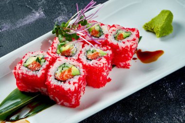 Japon suşisi avokado, somon balığı ve beyaz tabakta tobiko havyarı ile yuvarlanır. Kaliforniya 'yı döndürün. Üst görünüm