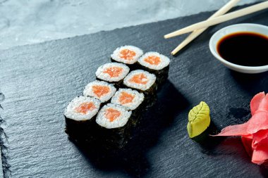 Siyah tahtada somon balıklı maki suşisi.
