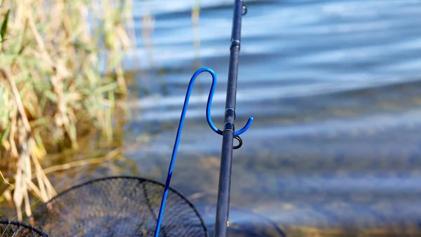 Fishing rod closeup on a prop and water background Stock Image