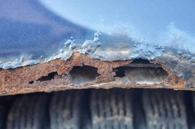 Mavi bir araba ağır aşınmış paslı tekerlek kemerler