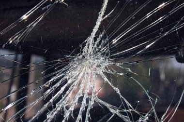 Çatlaklar ve cam kırıkları, bir nesnenin çarptığı bir pencereye çarpma noktasından yayılıyor.