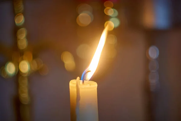 Luz de chama de vela à noite com bokeh no fundo escuro . — Fotografia de Stock