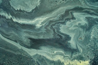 Benzin ve şampuanın büyük renkli lekeleri, asfalt yağmurda ıslak asfalta hızla yayılır.