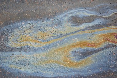 Asfalt üzerinde yağ lekesi olan soyut arkaplan. Asfalt Yolu 'ndaki benzin lekeleri doku ya da arkaplan olarak kullanılıyor..