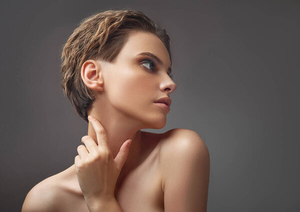 Portrait in profile of a charming girl with bare shoulders