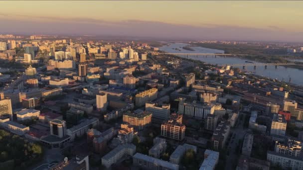 Filmik z lotu ptaka pięknego, spokojnego, wieczornego miasta nad rzeką. Przemysłowe obszary miasta. Dzielnica mieszkalna. Mieszkaniowe miasto. Wieczorna panorama metropolii. 4K — Wideo stockowe