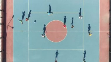 Futbol oynayan çocukların havadan tepeden aşağı görüntüsü. Çocuklar için özel futbol sahası. Çocuklarla ilgilenmek. Çocuklarla spor aktiviteleri. Yaz günü dinamik hareket. Çocuklar futbol takımında oynuyor.