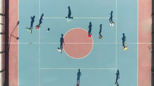 Aerial Top Down View of kids playing soccer. Special soccer field for children. Caring for children. Sports activities with children. Dynamic action in summer day. kidsn soccer team playing in the — Stock Video