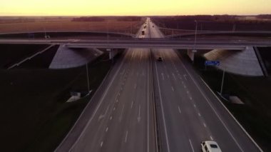 Otoyol boyunca giden kamyonlar. Günbatımında Highway Top View. Arabalar asfalt yol boyunca gider. Hava görünümü