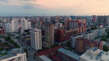 Sabah şehrinin üzerinde uçuyor. Şafak vakti şehir manzarası. Yeni binalar. Modern mimari. Güzel gün doğumu. 4K