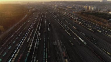 Havadan görünüşlü. Gün batımında demiryolu tasnif istasyonu. Birçok vagon endüstriyel bir nakliye istasyonunda. Sıralama istasyonunun büyük taşıma merkezinin panoramik görüntüsü. Gün batımında demiryolunda çatal.