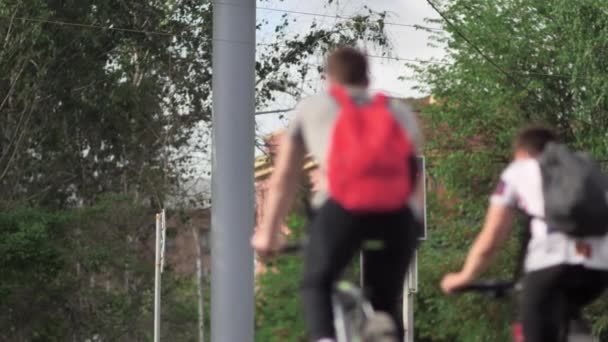 Fietsers stoppen bij een stoplicht. Milieuvriendelijk stadsvervoer. Op de fiets. Actieve stedelijke levensstijl concept. Een verkeerslicht op de kruising. Rood verkeerslicht verandert in groen. Langzame beweging. — Stockvideo