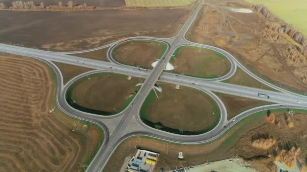 Bovenaanzicht van verkeersknooppunt. Vrachtwagens en auto 's rijden langs de snelweg. Top uitzicht op de snelweg op een zonnige dag. Autobahn. Vervoer logistiek — Stockvideo