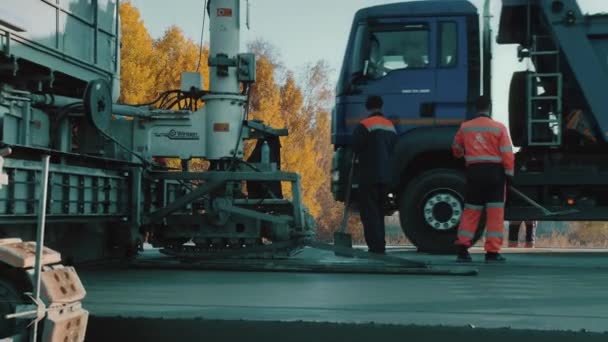 Gebiet Nowosibirsk, 2. Juli 2020. Nowosibirskautodor. Bautrupps pflastern neue Straßen. Schwere Maschinen. Der LKW fährt auf die Autobahn. Betonstraße. Bauwirtschaft. Fertiger. — Stockvideo