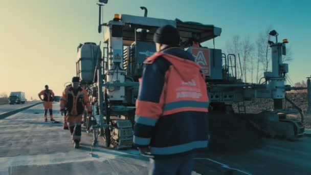 Novosibirsk Region, July 2, 2020. 도로 보수. 도로에서 일하 세요. 특수 장비를 만드는 사람들과 작업자들은 콘크리트 혼합물을 쌓는다. 도로 건설 공사중이다. 도로 보수. 중장비. 노동자들 — 비디오