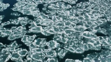 Güneşli bir günde nehir boyunca buz hareketi. Üst Manzara. Bir dağ nehrinde akıntılar. Buz kayması. Kış manzarası. Buzlu su eriyor. Çevre. Küresel ısınma ve iklim değişikliği kavramı.