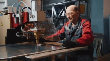 Profesyonel bir mühendis koruyucu ekranın arkasında metal bir levha ile çalışır. Zanaatkar, değirmenci ya da çilingir. Kıvılcımlar uçuşuyor. Gözlüklü ve özel giysili beyaz bir adam. Metal Çalışması