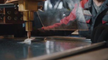 Koruyucu camın arkasında çalışan profesyonel bir işçi, metal işçiliği yapan bir makineyle çalışır. Zanaatkar, değirmenci ya da mühendis. İş sırasında kıvılcımlar uçuşuyor, yakın plan. Yavaş çekim