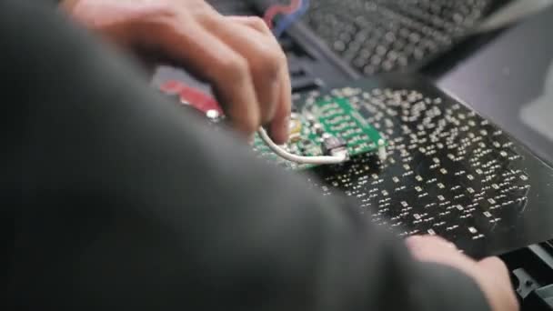 Un trabajador conecta un chip de semáforo en una fábrica. ledes, semáforos de ahorro de energía, cables, electrónica. Reparación y montaje de semáforos. — Vídeo de stock
