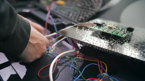 A worker connects the chips of a traffic light at a production site. Close-up. LEDs, energy saving traffic lights, wires, electronics. Repair and assembly of traffic lights. — Stock Video