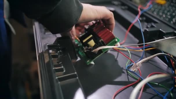 Um trabalhador conecta os chips de um semáforo em um local de produção. Close-up. matriz LED, bloco de luz, semáforos de poupança de energia, fios, electrónica. Reparação e montagem de semáforos. — Vídeo de Stock