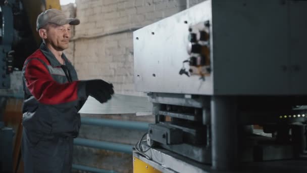 Engenheiro profissional trabalha com uma folha de metal em uma máquina-ferramenta. Mestre, serralheiro em produção. Máquina metalúrgica. Trabalho manual e automatizado na fábrica. — Vídeo de Stock