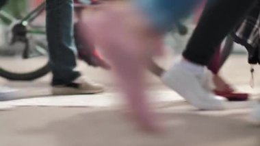 Arka planda bisikleti olan yayalar caddeyi geçiyor. Kalabalık yaya geçidi. Şehir hayatı. Mashikhlere binen isimsiz bir kalabalık. Yavaş çekim