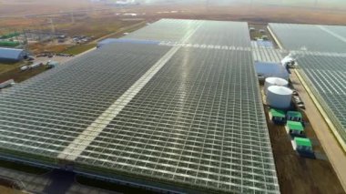 Geniş sera kompleksinin havadan görünüşü. Endüstriyel seralar sebze, meyve ve çiçek yetiştirmek için. Modern tarım. Büyük bir tarım kompleksinin en üst görüntüsü.