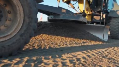 Motor-greyder yeni inşaat için toplu inşaat malzemesi seviyesinde. Yol yüzeyi tamiri. Yeni bir yol inşaatı. Yol yapımı makineler. Erkekler iş başında.