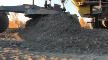 Motor-greyder yeni inşaat için toplu inşaat malzemesi seviyesinde. Yol yüzeyi tamiri. Yeni bir yol inşaatı. Yol yapımı makineler. Erkekler iş başında.