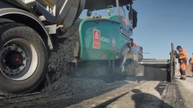 Novosibirsk bölgesi, 3 Ağustos 2020. Asfalt kaldırıma yakın çekim. Paver Hopper, yol onarımı, endüstri. Özel yol ekipmanları. Yol yapımı