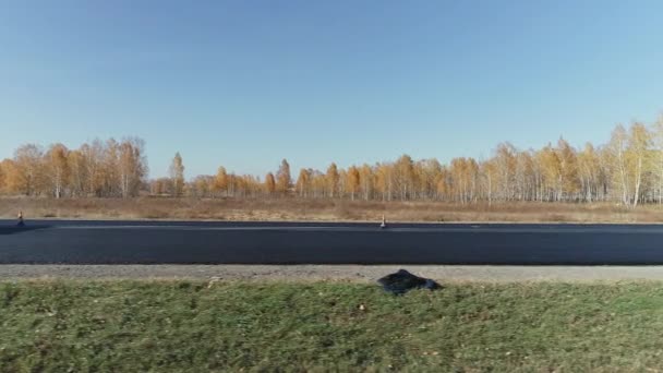 Novosibirsk region, 2020 년 8 월 3 일. 도로 표면 수리. 아스팔트 혼합물을 아스팔트 통에 넣을 준비를 한다. 도로 건설 차량. 막 깐 아스팔트층. — 비디오
