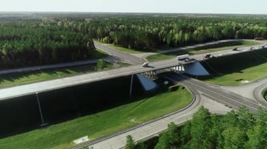 Bir yol kavşağında helikopter uçurmak. Kamyonlar ve arabalar asfalt yolda ilerliyor. Şehirlerarası kargo taşımacılığı, ulaşım lojistiği.