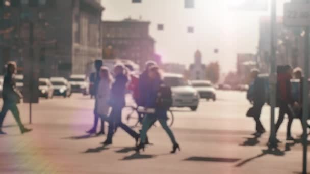 Desenfoque de la lente, fuera de foco. Una multitud de peatones está caminando a lo largo de la calle en el fondo de los coches que pasan. La gente camina por la gran ciudad. Vida en la ciudad. Movimiento lento — Vídeos de Stock