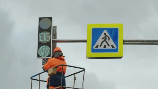 Een werknemer in een liftwieg repareert een LED-verkeerslicht. Verkeerstekens. LED-technologie. — Stockvideo