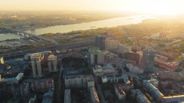 Novosibirsk, 15 Ağustos 2020. Nehirdeki büyük bir şehirde gün batımının havadan görünüşü. Köprüdeki arabaların hareketi. Güzel manzara. 