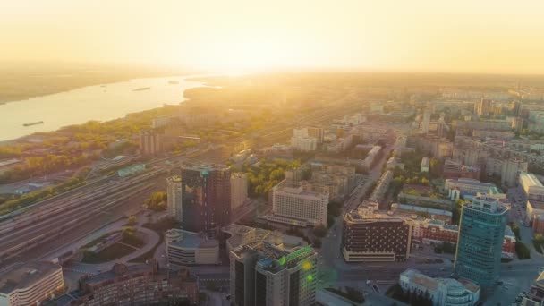 Novosibirsk，2020年8月15日。美丽的落日在河边的一座大城市里.美丽的风景。城里的铁路轨道。空中风景，阳光闪耀 — 图库视频影像