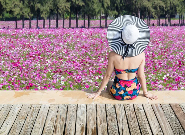 Mujer Joven Traje Baño Mirando Flores Rosadas Muelle Madera —  Fotos de Stock